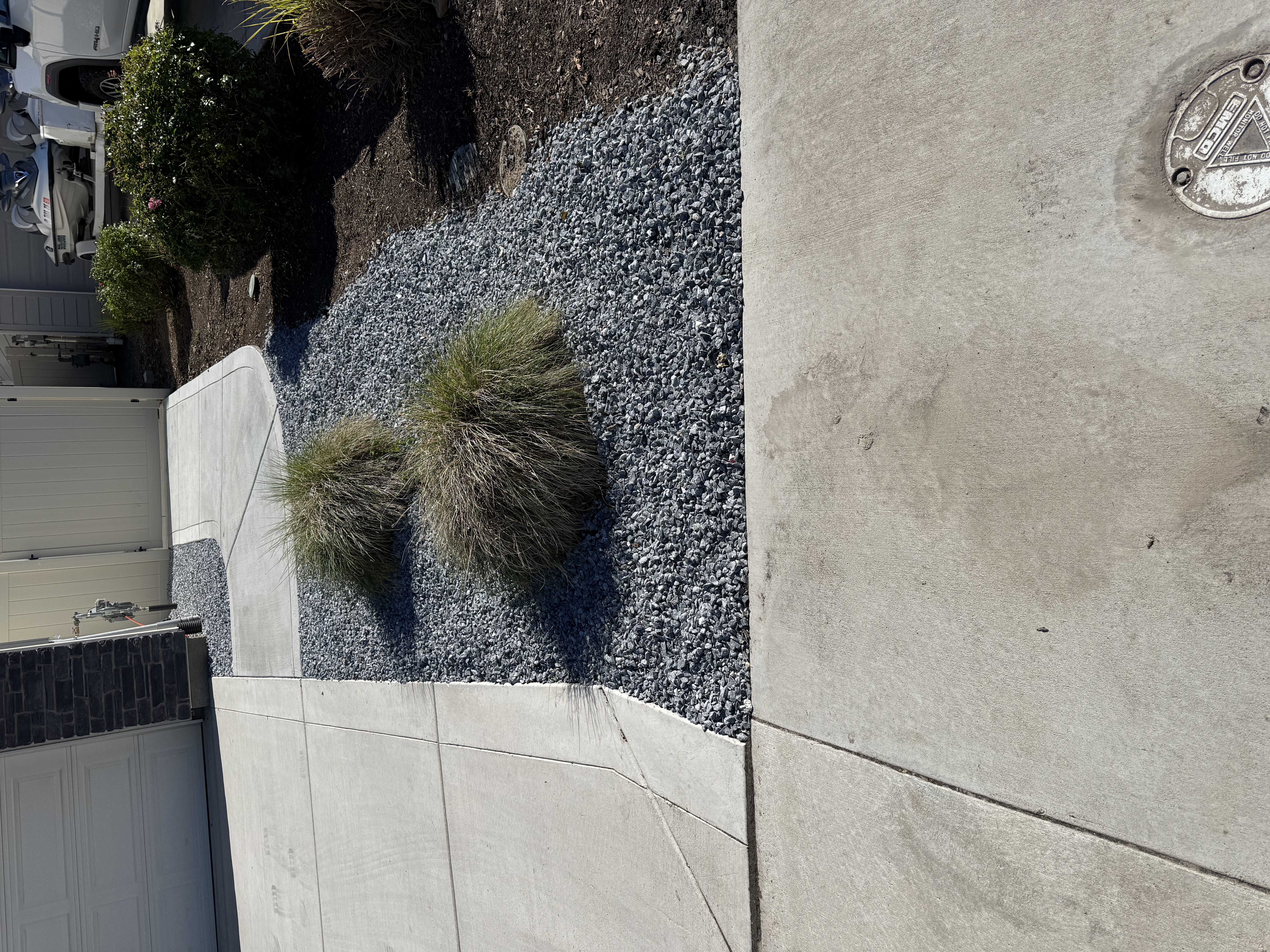 Finished front yard gravel beds with ornamental shrubs